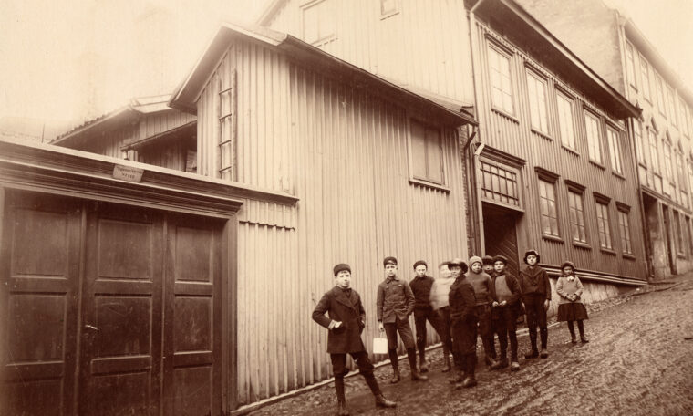 gammal bild på barn på gata framför hus