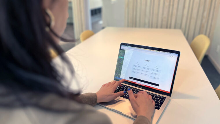 person med laptop på bordet, ChatGPT på skärmen
