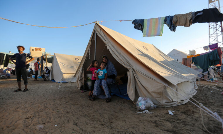 KHAN YUNIS, GAZA - OCTOBER 26: Children sit in a tent at a refugee camp set up for Palestinians seeking refuge along the Gaza Strip on October 26, 2023 in Khan Yunis, Gaza. Heading into a third week of heavy bombing from Israel, Gaza buckles under a shortage of basic needs including fuel, whilst several neighborhoods on the Gaza strip have been wiped out and thousands have died and hundreds of thousands have been displaced. On October 7, Hamas launched a deadly attack in southern Israel that sparked a retaliatory siege of Gaza. (Photo by Ahmad Hasaballah/Getty Images)