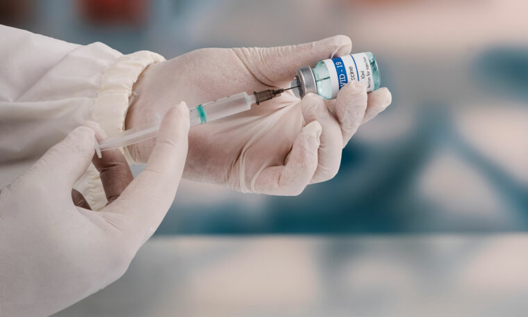 Läkare fyller en spruta med vaccin
