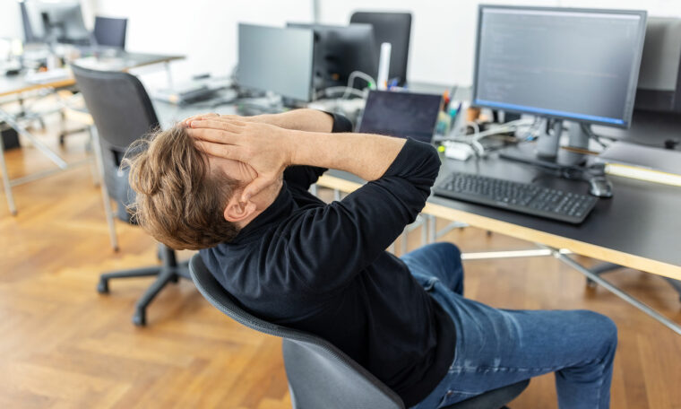 stressad man framför dator